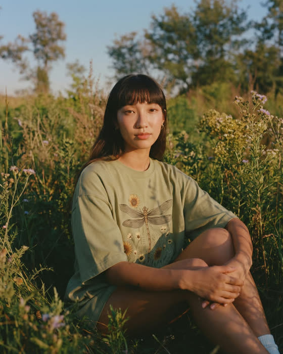Sitting in the meadow in a dragonfly print tee